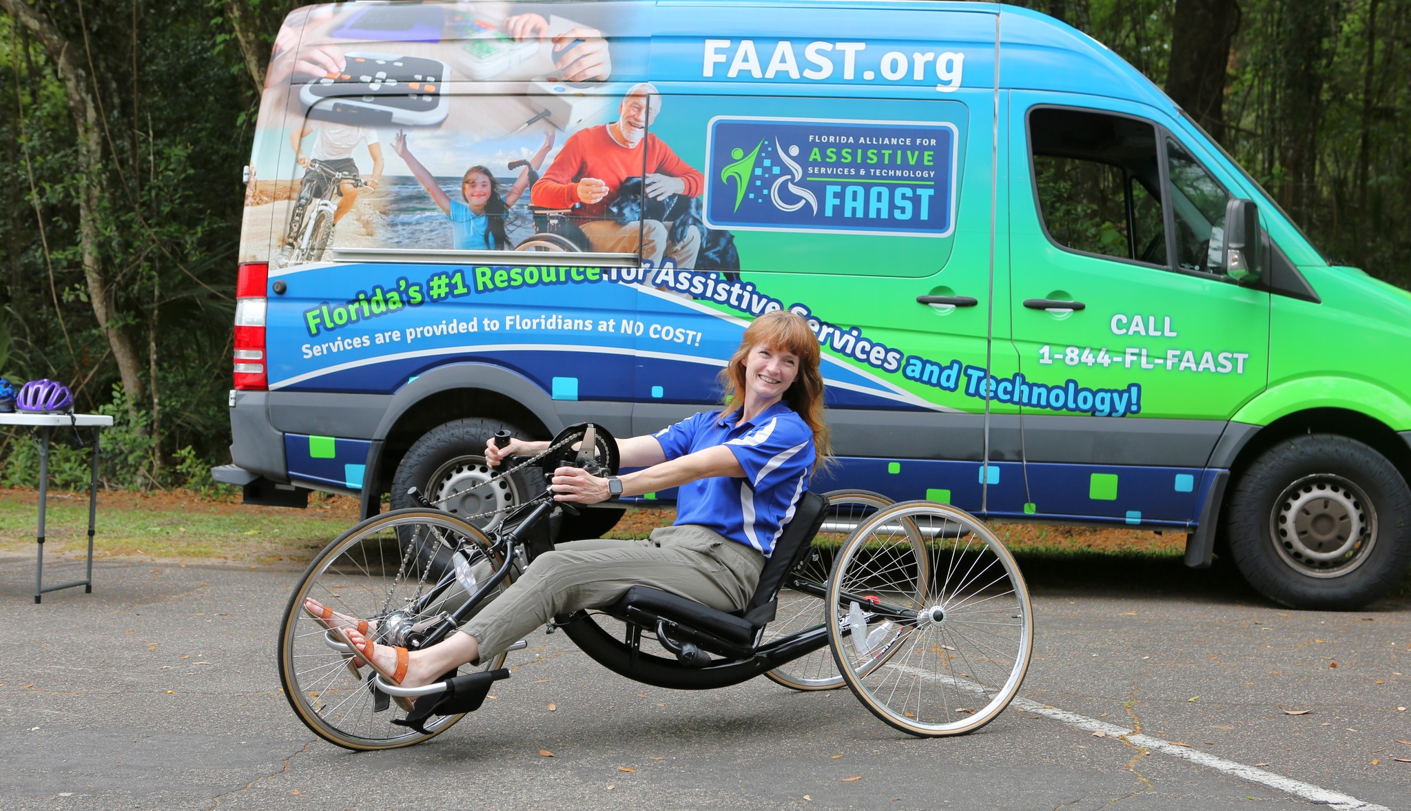 woman riding recumbant bike in front of FAAST van
