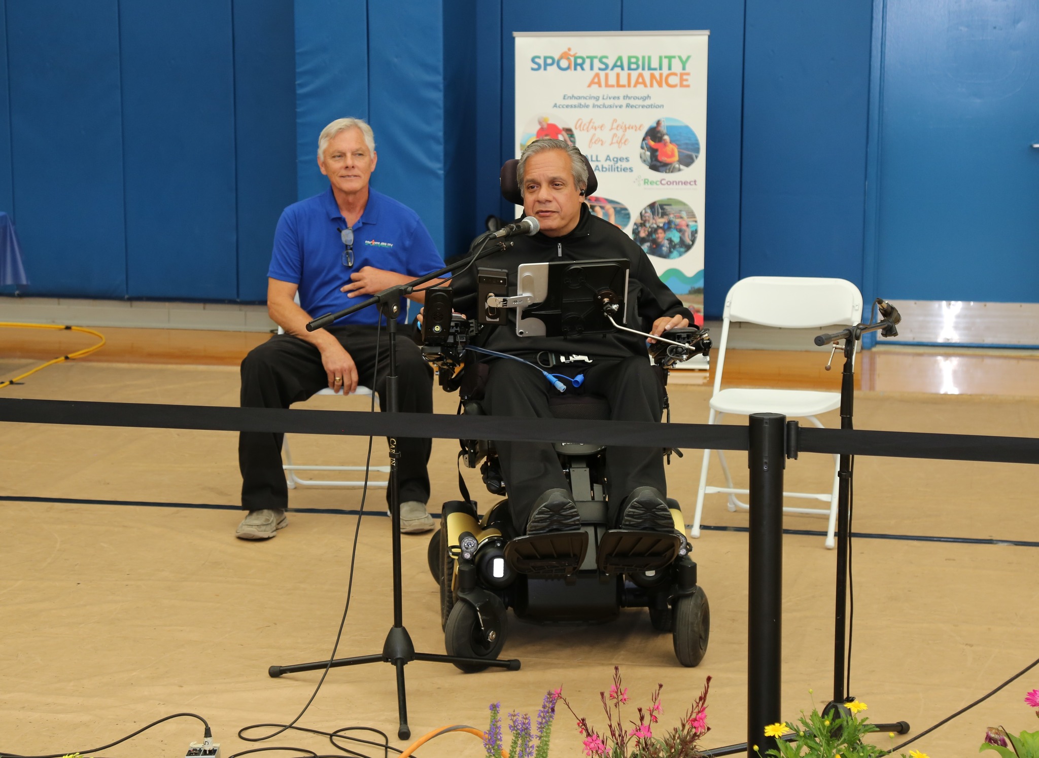 man in a wheelchair speaking into a microphone
