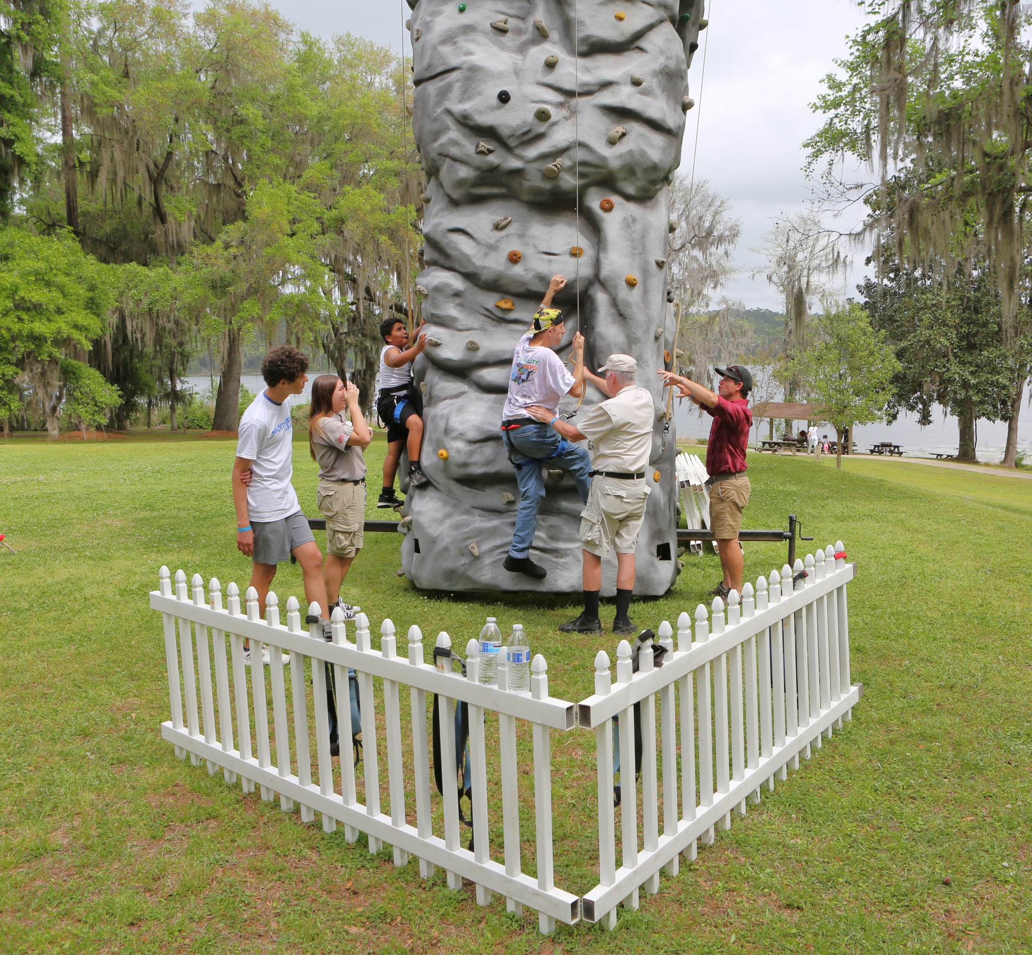 child and adult climbing a rock wall with assistance 