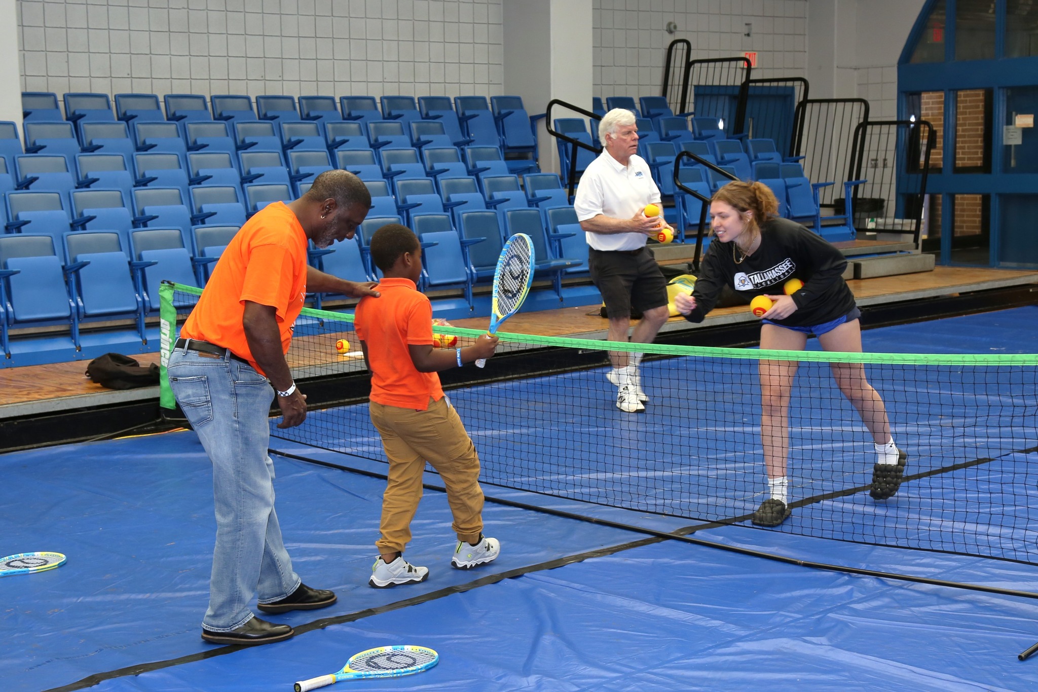 child and adult playing tennis 