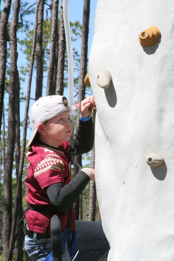 photo of a young boy rock wall climbing